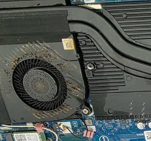 Ventoinha e dissipador do Acer Nitro 5 dentro do notebook, com fiapos de poeira presos nas aletas