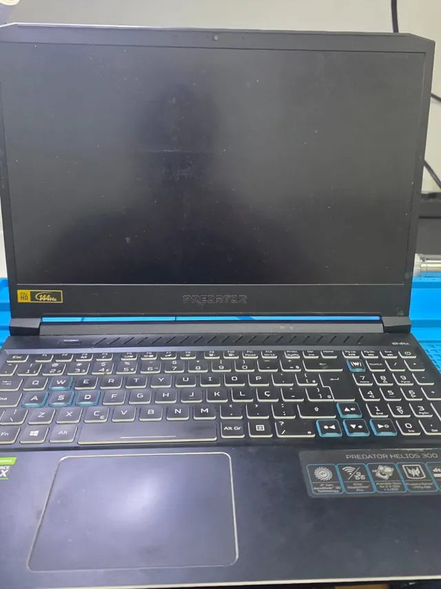 Notebook Acer Predator Helios 300 sobre a bancada de reparo com a tela apagada