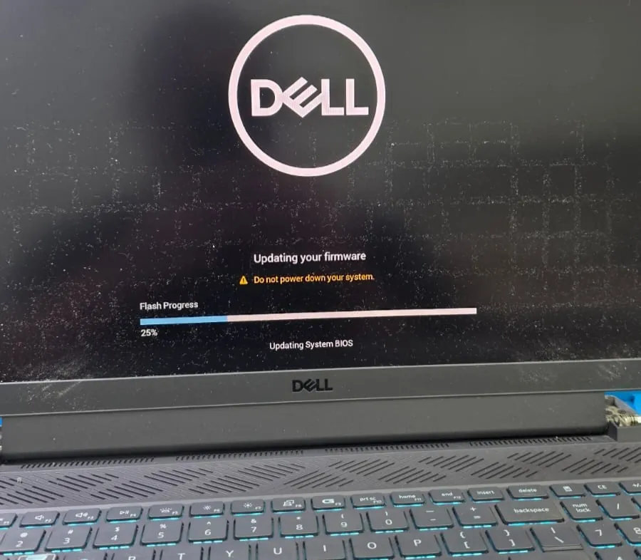 Tela do Dell G15 5511 com o logotipo da Dell e a mensagem Updating your firmware, com a barra de progresso em 25 por cento e o aviso para não desligar o sistema