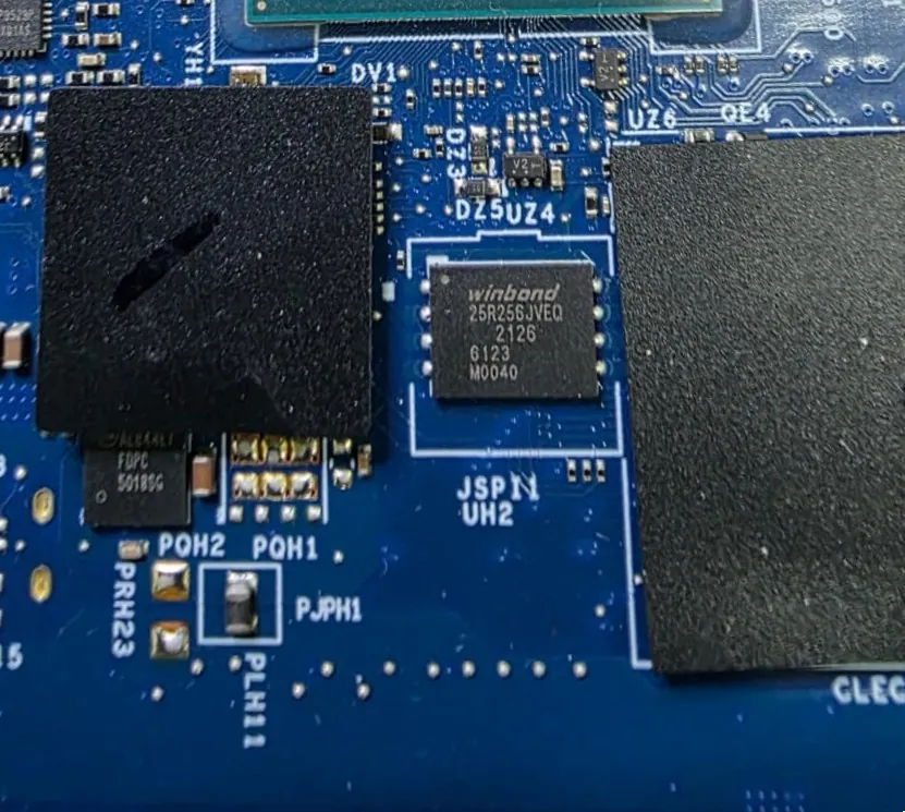 Chip de BIOS Winbond 25R256JVEQ na posição UH2 da placa do Dell G15 5511, entre duas almofadas térmicas pretas