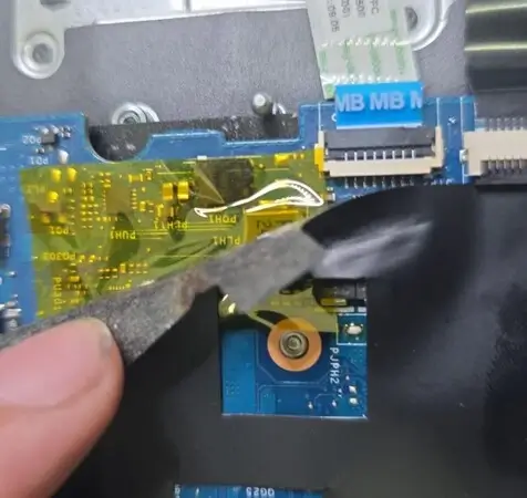 Placa de Dell G15 com fita Kapton amarela aplicada sobre a região reparada, perto de PQH1 e PLH1, e a manta preta de proteção sendo recolocada