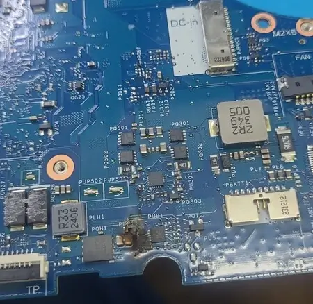 Placa-mãe de Dell G15 com marca de queimado ao lado dos componentes PQH1 e PLH1, perto do conector DC-in e do conector da bateria