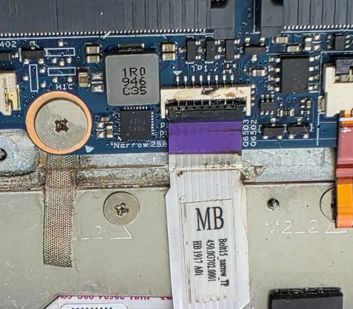Cabo flat com trava roxa preso ao conector na placa do Dell Inspiron 5584, com resíduo claro em volta do conector e a etiqueta de identificação do cabo
