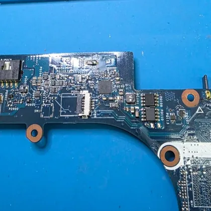 Região de entrada de energia da placa-mãe de um Dell Inspiron 7520 na bancada de reparo