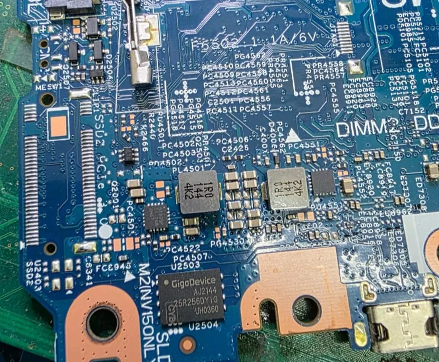 Região da placa de um Dell Latitude 3420 mostrando o chip de BIOS GigaDevice 25R256DY, abaixo de dois indutores, ao lado do slot M.2 e da etiqueta M2 NVMe