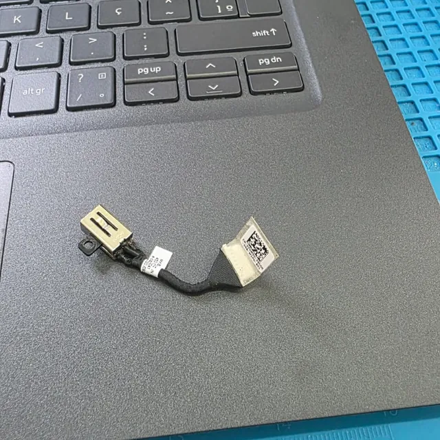 Jack de energia do Dell Latitude 3520 com o cabo curto, apoiado sobre o palmrest