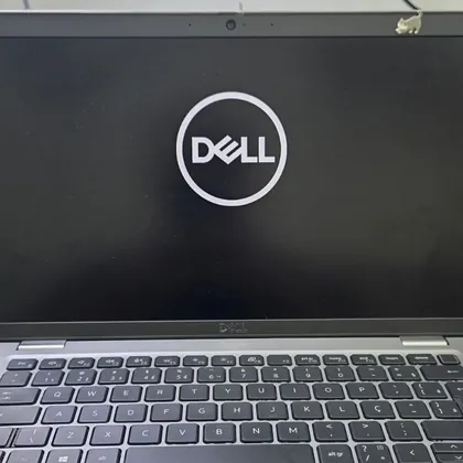 Dell Latitude 5420 ligado na bancada com o logotipo da Dell na tela depois do banho químico e do reparo