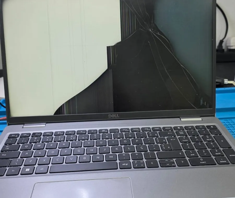 Dell Precision 3571 ligado com a tela trincada em teias a partir de um ponto de impacto na parte de cima, metade da imagem apagada e a outra metade com listras verticais