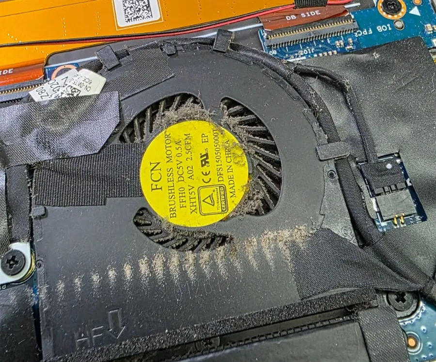 Cooler de um Dell XPS 13 9360 dentro do notebook, com camada de poeira nas pás e na saída de ar