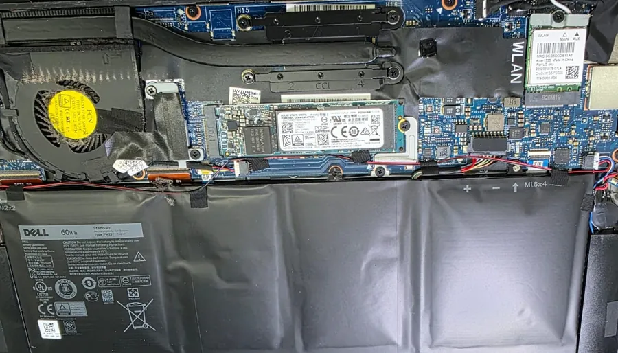 Interior de um Dell XPS 13 9360 com a tampa aberta, mostrando o cooler, o SSD M.2 e a bateria interna na parte inferior