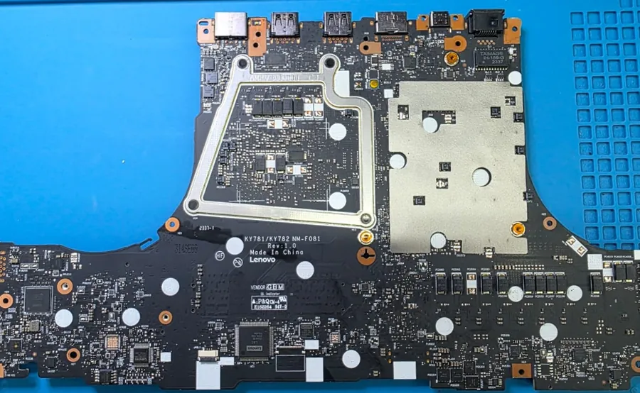 Placa-mãe do Lenovo Legion Pro 7 sobre o tapete da bancada, com o dissipador de cobre e os conectores de entrada e saída na parte superior