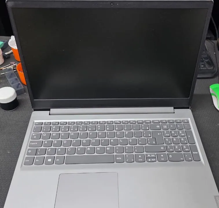 Lenovo IdeaPad S145 aberto sobre a bancada, com o teclado e o palmrest cinza limpos e a tela desligada