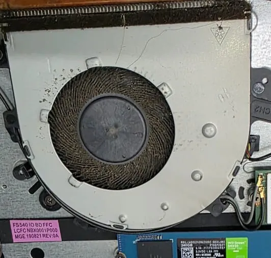 Ventoinha de um Lenovo IdeaPad S145 com poeira nas pás e no corpo, e as aletas do dissipador entupidas na parte superior